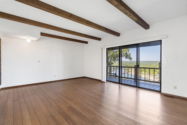 spare room featuring baseboards, dark wood-type flooring, beam ceiling, and visible vents