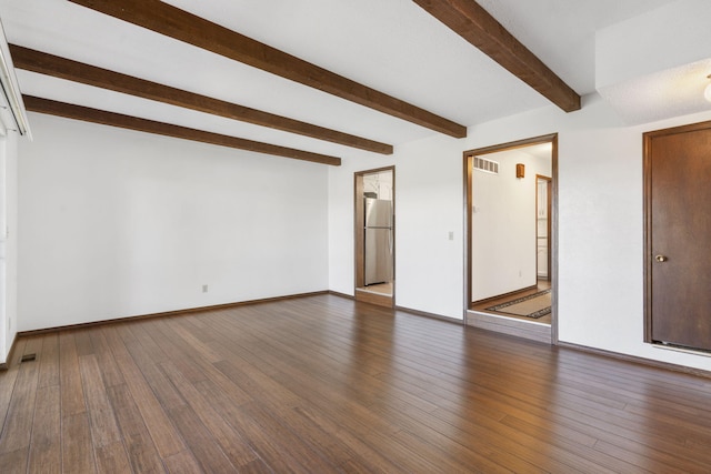 unfurnished living room featuring wood finished floors, beam ceiling, baseboards, and visible vents