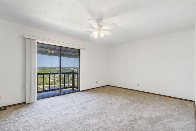 empty room with ceiling fan, baseboards, a textured ceiling, and carpet