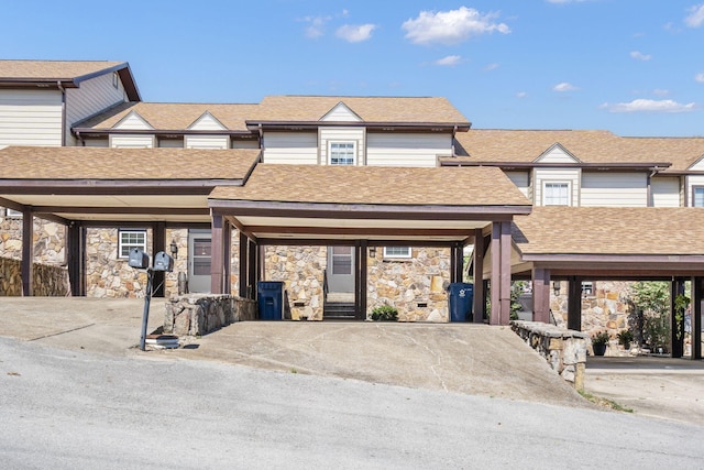 townhome / multi-family property featuring roof with shingles and stone siding