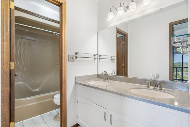 full bathroom featuring tile patterned flooring, double vanity, toilet, and a sink