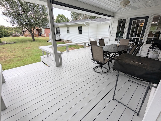 wooden terrace with a lawn and ceiling fan