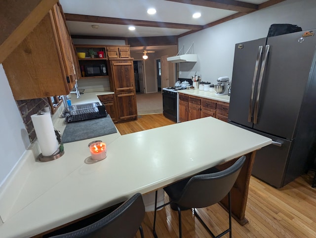 kitchen featuring black appliances, light hardwood / wood-style flooring, decorative backsplash, ceiling fan, and beamed ceiling