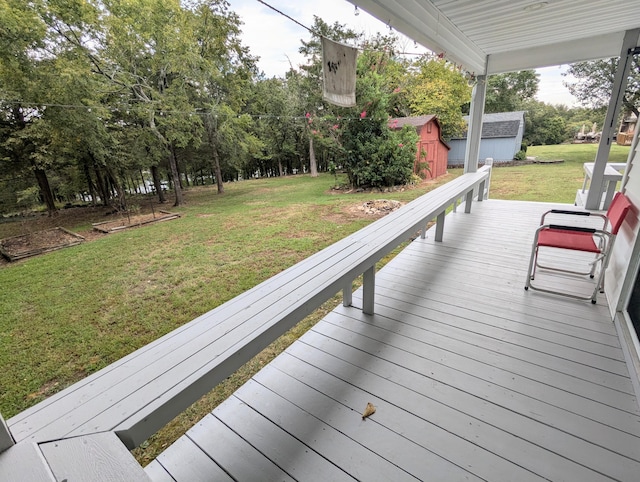 wooden terrace with a lawn and a shed