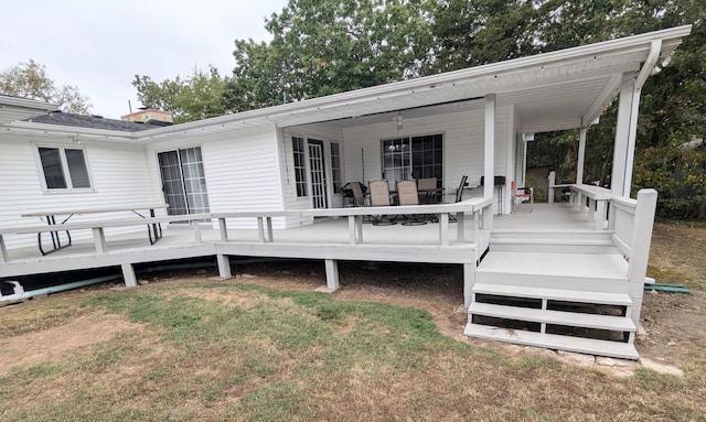 wooden deck with covered porch and a yard