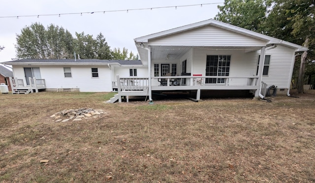 rear view of house with a lawn and a deck