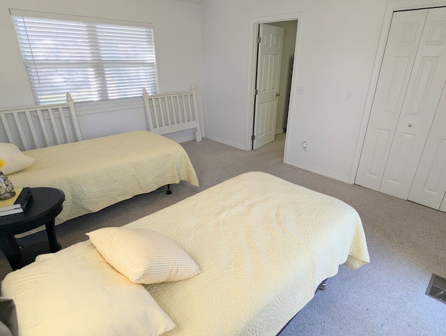 bedroom featuring light carpet and a closet