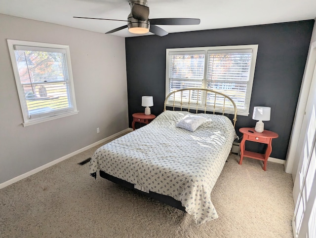 carpeted bedroom featuring multiple windows and ceiling fan