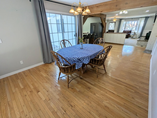 dining room featuring beamed ceiling, light hardwood / wood-style floors, and a chandelier