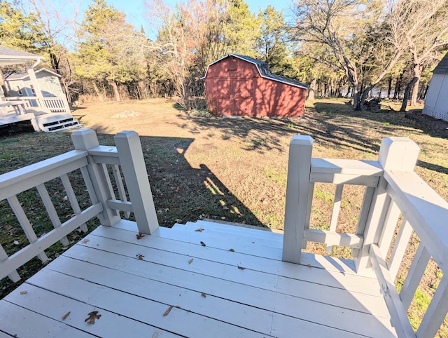 wooden terrace featuring a storage unit and a lawn