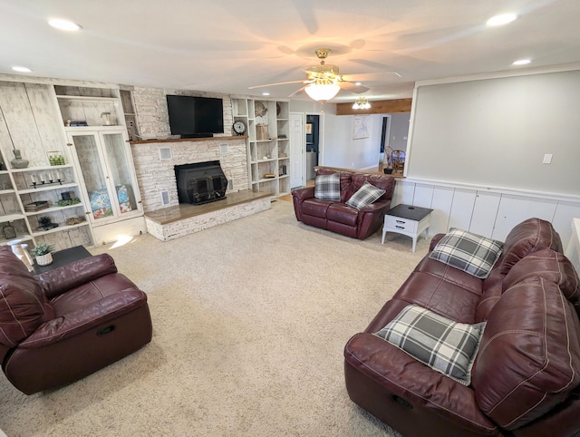 carpeted living room featuring built in shelves and ceiling fan