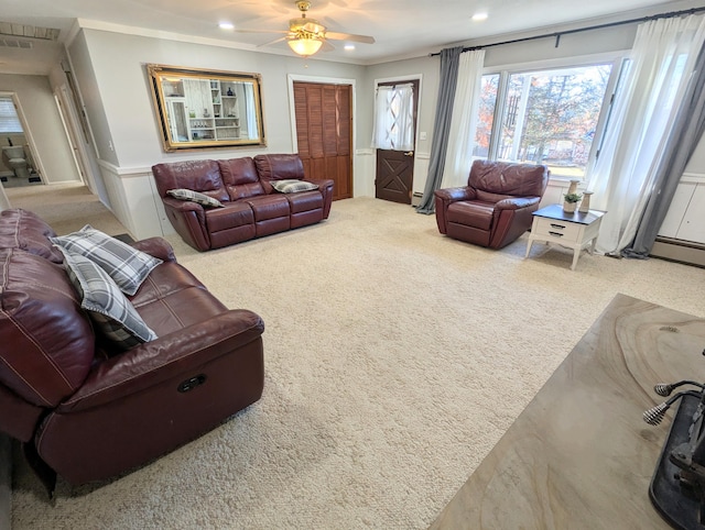 living room with carpet flooring, crown molding, and ceiling fan