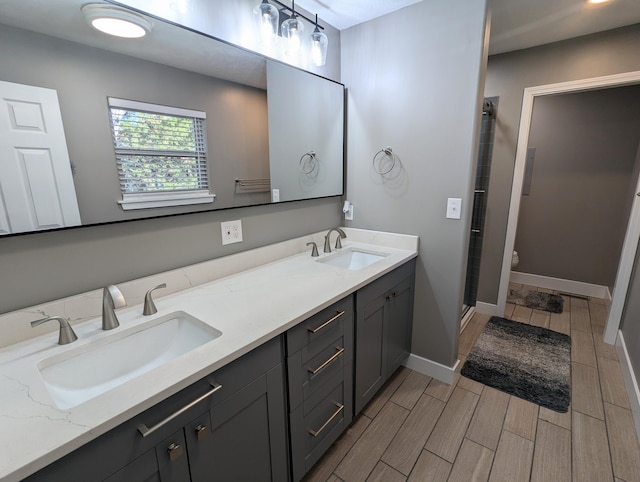 bathroom featuring wood-type flooring, vanity, toilet, and walk in shower