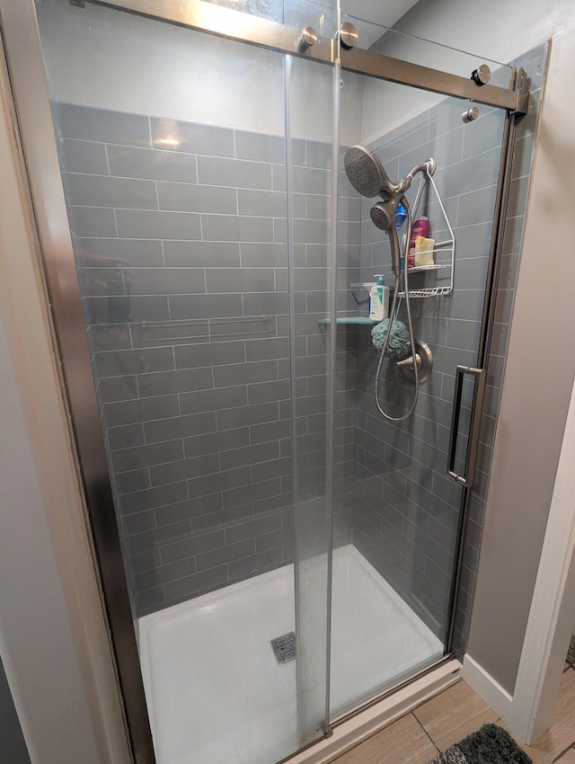 bathroom with hardwood / wood-style flooring and walk in shower