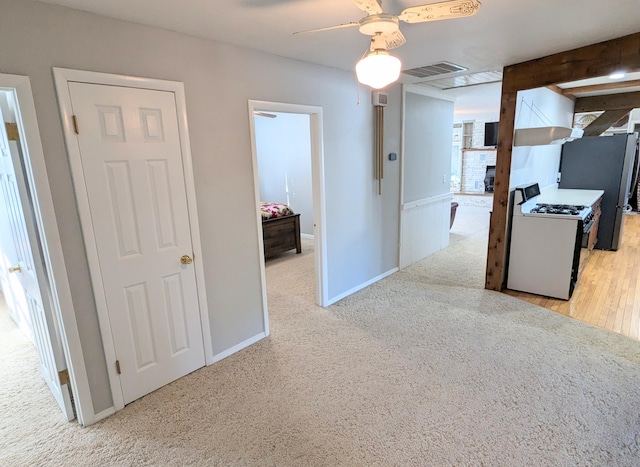 kitchen with light wood-type flooring, ceiling fan, a fireplace, white stove, and stainless steel refrigerator