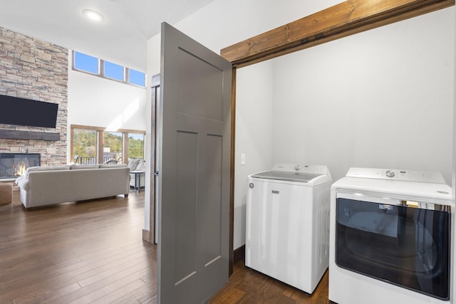 laundry room with a stone fireplace, dark hardwood / wood-style floors, and washer and dryer