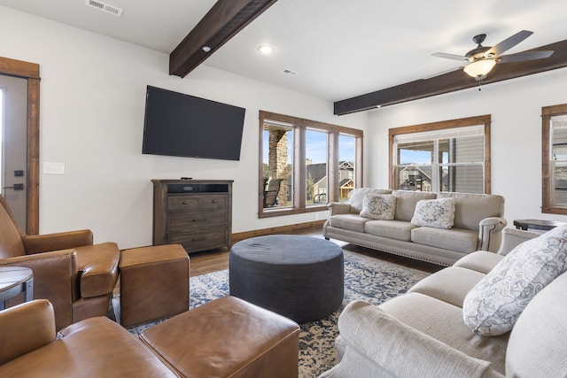 living room featuring hardwood / wood-style flooring, beamed ceiling, and ceiling fan