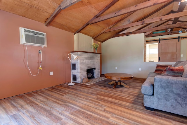 unfurnished living room with a wall unit AC, a barn door, wood ceiling, and light hardwood / wood-style floors