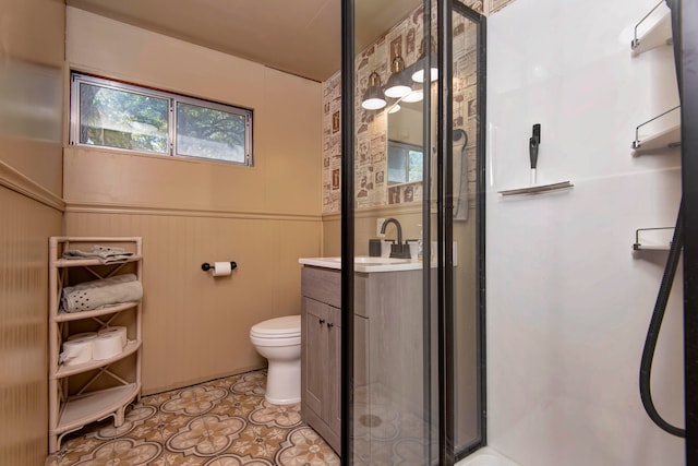 bathroom featuring vanity, an enclosed shower, and toilet