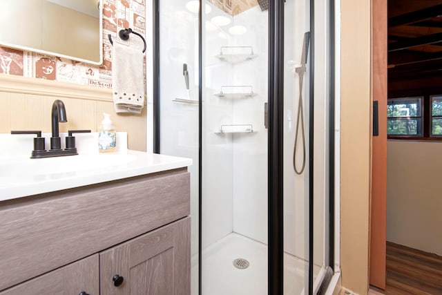 bathroom with hardwood / wood-style floors, vanity, and a shower with door