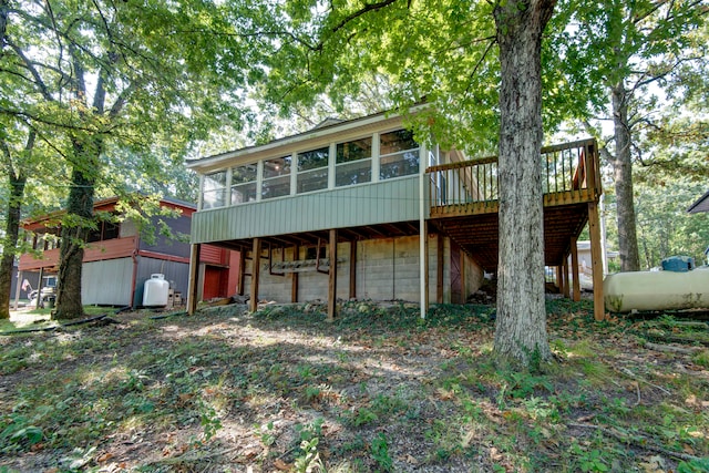 rear view of house with a sunroom and a deck