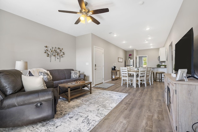 living room with ceiling fan and light hardwood / wood-style floors