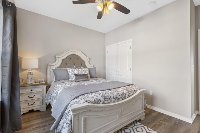 bedroom with a closet, dark hardwood / wood-style floors, and ceiling fan