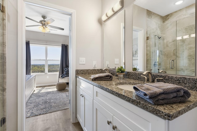 bathroom featuring hardwood / wood-style floors, a shower with shower door, vanity, and ceiling fan