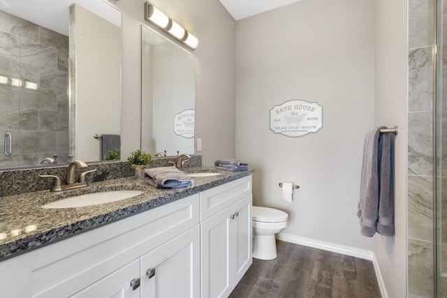 bathroom with vanity, toilet, a shower with door, and hardwood / wood-style flooring