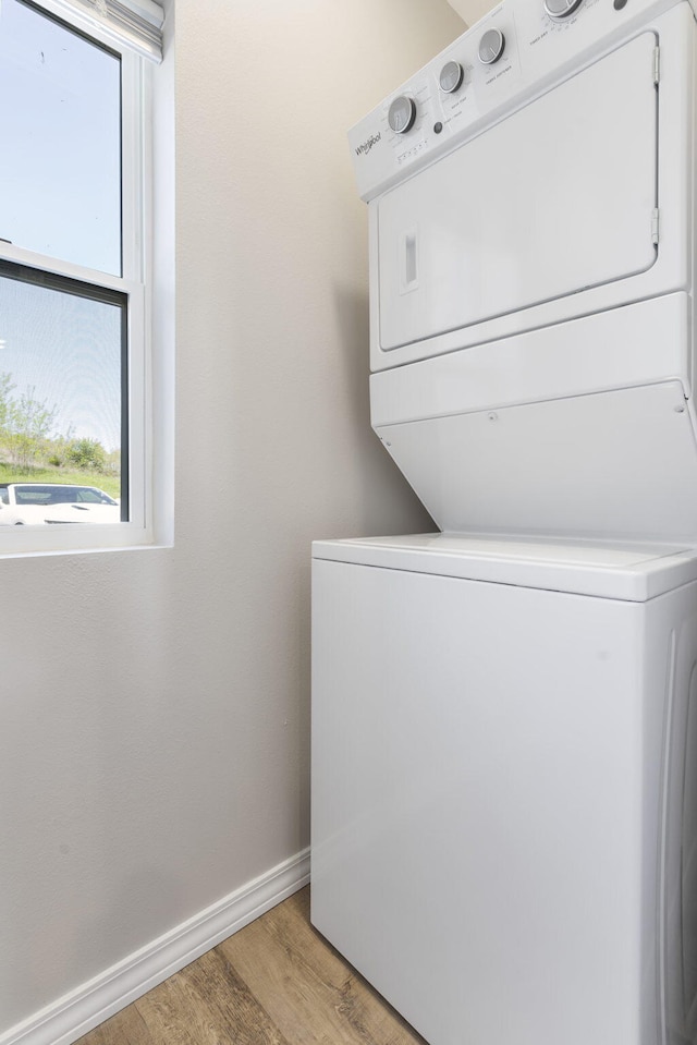 washroom featuring light hardwood / wood-style floors and stacked washer and dryer