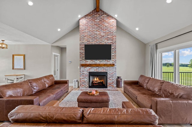 living room with hardwood / wood-style floors, beam ceiling, high vaulted ceiling, and a brick fireplace