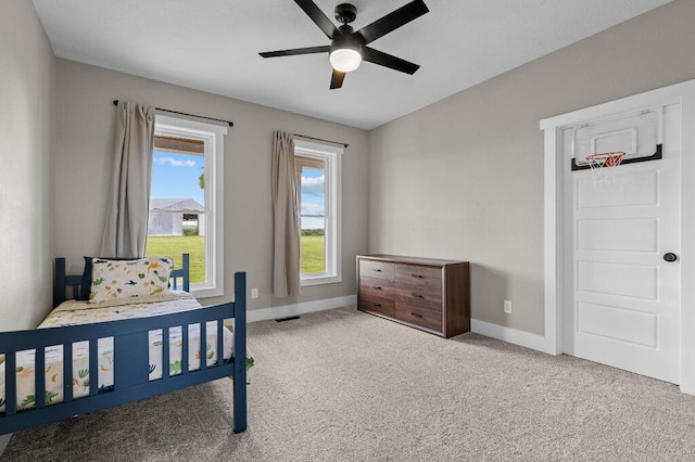 bedroom featuring carpet flooring, multiple windows, and ceiling fan