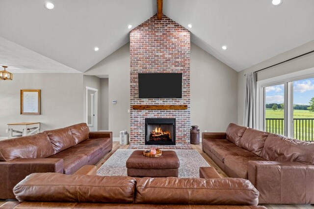 living area with baseboards, beam ceiling, a brick fireplace, and wood finished floors