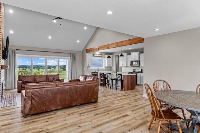 living room with light wood finished floors, recessed lighting, and high vaulted ceiling