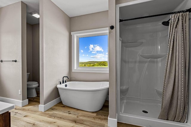 full bath featuring a shower stall, toilet, wood finished floors, and baseboards