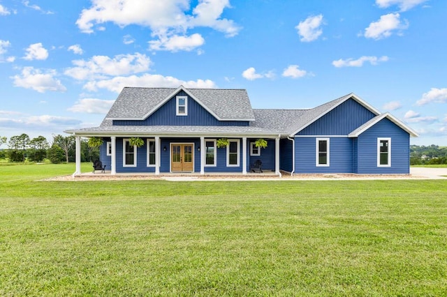 view of front of home featuring a front lawn, a porch, board and batten siding, and a shingled roof