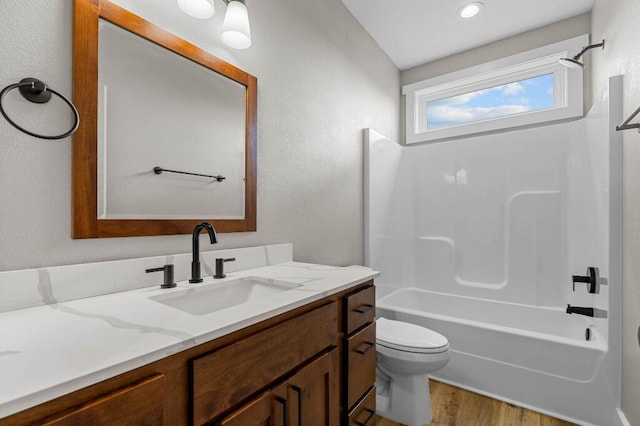 bathroom featuring shower / bathing tub combination, toilet, wood finished floors, and vanity