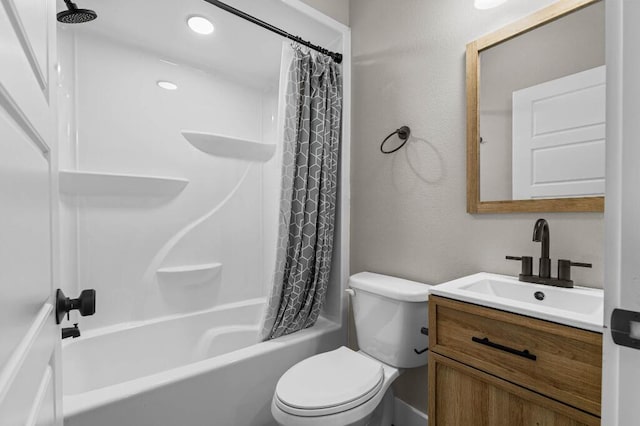 bathroom with toilet, vanity, a textured wall, and shower / bathtub combination with curtain