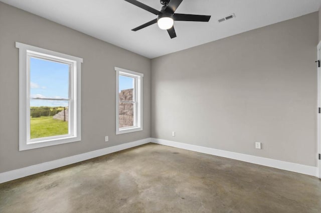 empty room featuring visible vents, baseboards, concrete flooring, and a ceiling fan