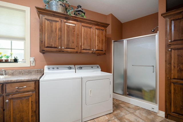 laundry room with independent washer and dryer, light tile patterned floors, and cabinets