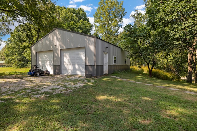 view of side of home with a garage, a yard, and an outbuilding