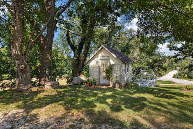 view of front of property with a front yard and a storage shed