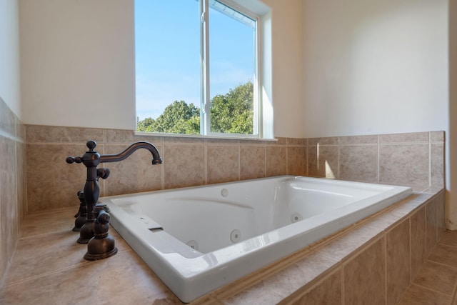 bathroom featuring a healthy amount of sunlight, tile patterned flooring, and tiled tub