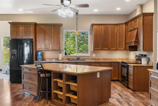 kitchen with custom exhaust hood, dark wood-type flooring, black appliances, and a kitchen island