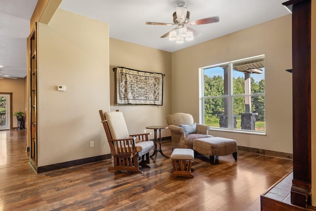 sitting room with ceiling fan and dark hardwood / wood-style flooring