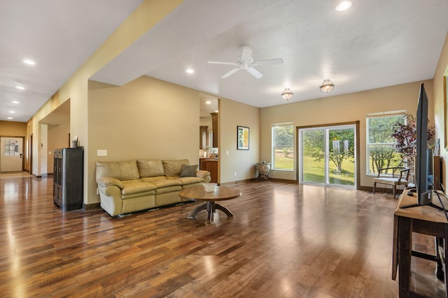 living room featuring ceiling fan and dark wood-type flooring