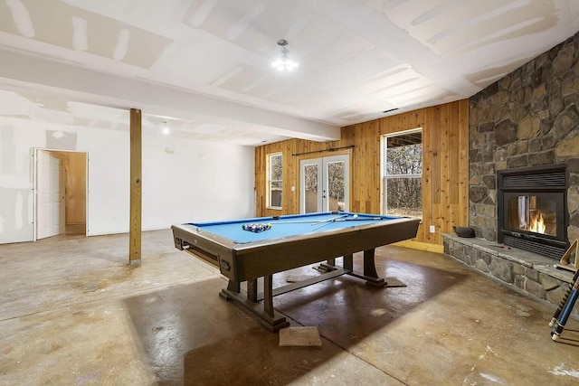 recreation room featuring french doors, beam ceiling, pool table, wood walls, and concrete floors