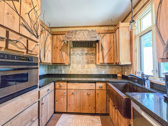 kitchen with dark stone counters, decorative light fixtures, oven, and tasteful backsplash