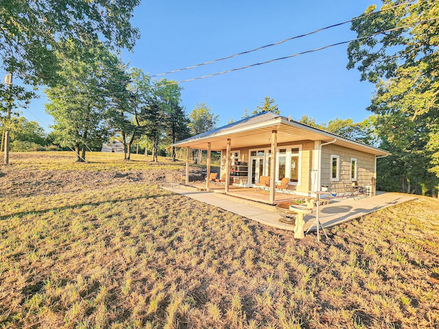 rear view of house featuring a yard and a patio area