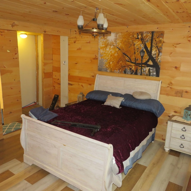 bedroom featuring wood walls, wood ceiling, and light hardwood / wood-style flooring